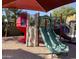 A community playground featuring a bright red slide and green climbing structure with a red sun shade overhead at 900 S 94Th St # 1166, Chandler, AZ 85224