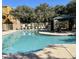 Community pool with lounge chairs, lifeguard ring and covered seating area, surrounded by trees, under a sunny sky at 900 S 94Th St # 1166, Chandler, AZ 85224