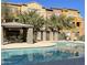 Community pool with inviting turquoise water, lounge chairs, and covered seating area, surrounded by trees and colorful buildings at 900 S 94Th St # 1166, Chandler, AZ 85224