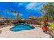 Sparkling backyard pool with palm trees, rock features, and a cozy outdoor dining area at 9309 E Obispo Ave, Mesa, AZ 85212
