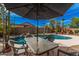 Outdoor dining area with a table overlooking a sparkling pool and relaxing backyard landscape at 9309 E Obispo Ave, Mesa, AZ 85212