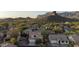 Aerial shot of a desert community, featuring houses with tile roofs, and dramatic mountain views at 9548 E Kiva Ln, Gold Canyon, AZ 85118