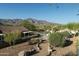 Mountain view from the backyard, showcasing desert plants, a walking path, neighboring roofs, and a community pool at 9548 E Kiva Ln, Gold Canyon, AZ 85118