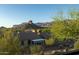 Backyard with a view of neighboring roofs, native trees and shrubs, and the iconic Arizona mountain range at 9548 E Kiva Ln, Gold Canyon, AZ 85118