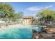 Community pool with rock waterfall feature, lounge chairs, and desert landscaping at 9548 E Kiva Ln, Gold Canyon, AZ 85118
