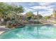 Sparkling community pool with rock waterfall feature and desert landscaping at 9548 E Kiva Ln, Gold Canyon, AZ 85118