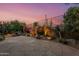 Picturesque backyard featuring a stone patio, desert landscaping, and elegant wrought iron fencing at 9566 E Raindance Trl, Scottsdale, AZ 85262