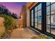 Charming patio featuring desert landscaping and a peek into the home through large glass windows at 9566 E Raindance Trl, Scottsdale, AZ 85262
