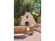 Close up of an outdoor fireplace with comfortable seating and lush greenery, providing a serene backyard retreat at 9849 E Topaz Dr, Scottsdale, AZ 85258