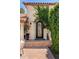 Beautiful arched front door with decorative ironwork and lush green vines at 9849 E Topaz Dr, Scottsdale, AZ 85258