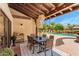 Covered outdoor dining area with a view of the pool and landscaped backyard at 9849 E Topaz Dr, Scottsdale, AZ 85258