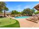 Spacious backyard featuring a pool, putting green, lounge chairs, and lush landscaping, ideal for outdoor enjoyment at 9849 E Topaz Dr, Scottsdale, AZ 85258