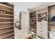 Bright walk-in closet boasts custom shelves, drawers, and convenient access to the sink and vanity area at 9849 E Topaz Dr, Scottsdale, AZ 85258