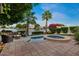 Secluded backyard featuring a spa, firepit, lush landscaping, and serene lake views at 1700 E Lakeside Dr # 12, Gilbert, AZ 85234