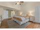 Comfortable bedroom with wood floors, a decorative rug, a ceiling fan, and a sliding barn door to the ensuite at 1700 E Lakeside Dr # 12, Gilbert, AZ 85234