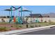 Community playground with shaded play structures and a covered picnic area surrounded by green space at 17425 W Eva St, Waddell, AZ 85355
