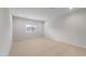 A sunlit, empty bedroom with plush carpet and a large window at 17782 W Getty Dr, Goodyear, AZ 85338