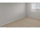 Bright bedroom featuring neutral carpet, window, and base trim at 17782 W Getty Dr, Goodyear, AZ 85338