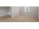 Bright bedroom with neutral carpet, white walls, a window with blinds, and a white door with chrome handle at 17782 W Getty Dr, Goodyear, AZ 85338