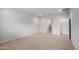 Empty, light-filled bedroom with neutral carpet, white walls, and a door to an adjoining bathroom at 17782 W Getty Dr, Goodyear, AZ 85338
