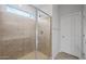 Tiled shower with glass enclosure and brushed nickel hardware in a modern bathroom at 17782 W Getty Dr, Goodyear, AZ 85338