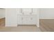 Dual-sink vanity in bathroom with tile floors, carpeting, and white cabinets at 37341 W San Clemente St, Maricopa, AZ 85138