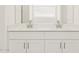 Bathroom vanity with double sinks and large mirror with white cabinets at 37341 W San Clemente St, Maricopa, AZ 85138