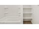 Clean bathroom with a tub, shower, and built-in shelves for storage at 37341 W San Clemente St, Maricopa, AZ 85138