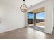 Bright dining area with neutral tile flooring, modern chandelier, and sliding glass door to the backyard at 37341 W San Clemente St, Maricopa, AZ 85138