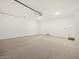 A brightly lit two-car garage with epoxy flooring and a white door at 37341 W San Clemente St, Maricopa, AZ 85138