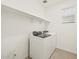 Well-lit laundry room with white washer and dryer, plus convenient shelving at 37341 W San Clemente St, Maricopa, AZ 85138