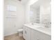 Bright bathroom featuring double sinks, white cabinets, and a large mirror at 37373 W San Clemente St, Maricopa, AZ 85138