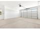 Spacious garage features a concrete floor, a water heater, and a large garage door at 37373 W San Clemente St, Maricopa, AZ 85138