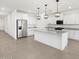 A gourmet kitchen with stainless steel appliances, granite countertops, and modern pendant lighting at 37373 W San Clemente St, Maricopa, AZ 85138