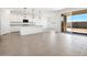Open concept kitchen with a granite island and stainless appliances leading to outdoor patio via glass sliding doors at 37373 W San Clemente St, Maricopa, AZ 85138