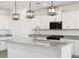 Kitchen island features granite countertops, stainless steel faucet and appliances, with a black gas range at 37373 W San Clemente St, Maricopa, AZ 85138