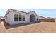 A view of the spacious dirt backyard and covered patio with view to house facade at 42064 N Golden Trl, San Tan Valley, AZ 85140