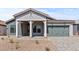 Inviting single-story home with desert landscaping, covered entry and stone driveway leading to a two-car garage at 42064 N Golden Trl, San Tan Valley, AZ 85140