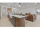 Stylish kitchen island with seating, sink, dishwasher, and elegant pendant lighting at 42064 N Golden Trl, San Tan Valley, AZ 85140