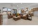 Inviting open-concept living room with a large sectional sofa, modern furnishings, and kitchen access at 42064 N Golden Trl, San Tan Valley, AZ 85140
