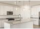 Bright kitchen boasts granite countertops, pendant lighting, stainless appliances, and white cabinetry at 4347 W Hannah St, San Tan Valley, AZ 85144