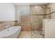 Bathroom featuring a soaking tub, tiled walk-in shower with pebble floor, and window at 9802 N 77Th St, Scottsdale, AZ 85258