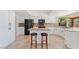 Kitchen features white cabinets, an island with seating, stainless steel appliances, and granite counters at 9802 N 77Th St, Scottsdale, AZ 85258