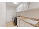Efficient laundry room features a utility sink, built-in cabinets, and modern washer and dryer at 9802 N 77Th St, Scottsdale, AZ 85258