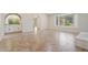 Open living area with a bay window, arched doorways, and tiled flooring at 9802 N 77Th St, Scottsdale, AZ 85258