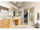 Bright main bathroom with double sinks, a vanity area, and a large mirror door to the walk-in closet at 15140 E Staghorn Dr, Fountain Hills, AZ 85268