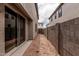 Narrow backyard space with neutral colored walls on each side, and a sliding glass door to enter home at 15587 S 180Th Ln, Goodyear, AZ 85338