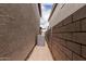 A narrow space between two homes that features a textured wall, an AC unit and minimal landscaping at 15587 S 180Th Ln, Goodyear, AZ 85338