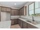 View of kitchen with stainless steel sink, granite counters, and sleek brown cabinets at 15587 S 180Th Ln, Goodyear, AZ 85338
