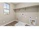 Bright laundry room with wooden tile floors, a window with mountain views and overhead storage shelf at 15587 S 180Th Ln, Goodyear, AZ 85338